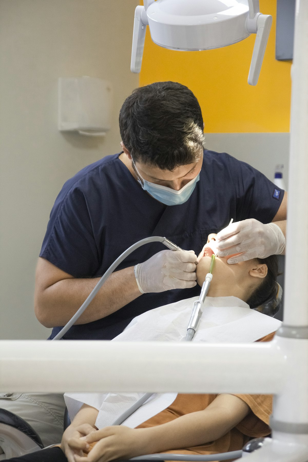 Odontólogo aplicando anestesia local a un paciente durante una cirugía dental sin dolor