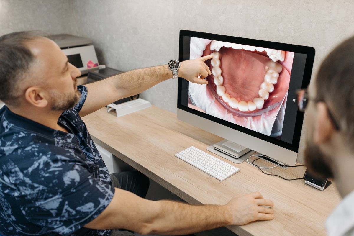 Dentista mostrando en pantalla el modelo digital de la boca, primer paso del flujo digital en odontología