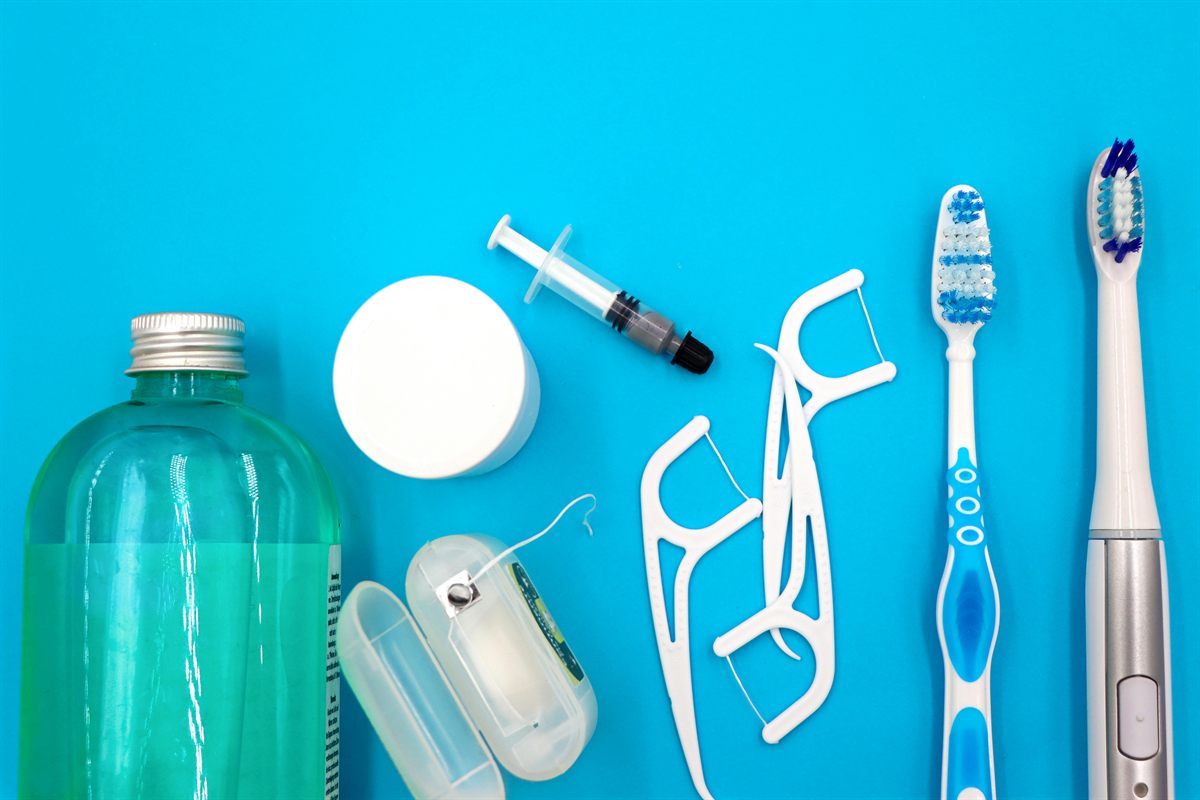 Cepillo dental de cerdas suaves junto a un colutorio de clorhexidina para la higiene bucal tras una cirugía dental