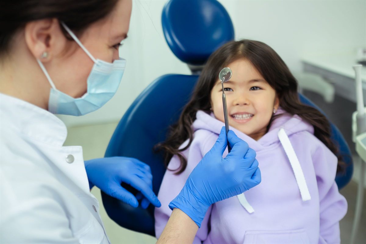 Odontopediatra explicando al niño qué va a hacer con un peluche para reducir el miedo dental