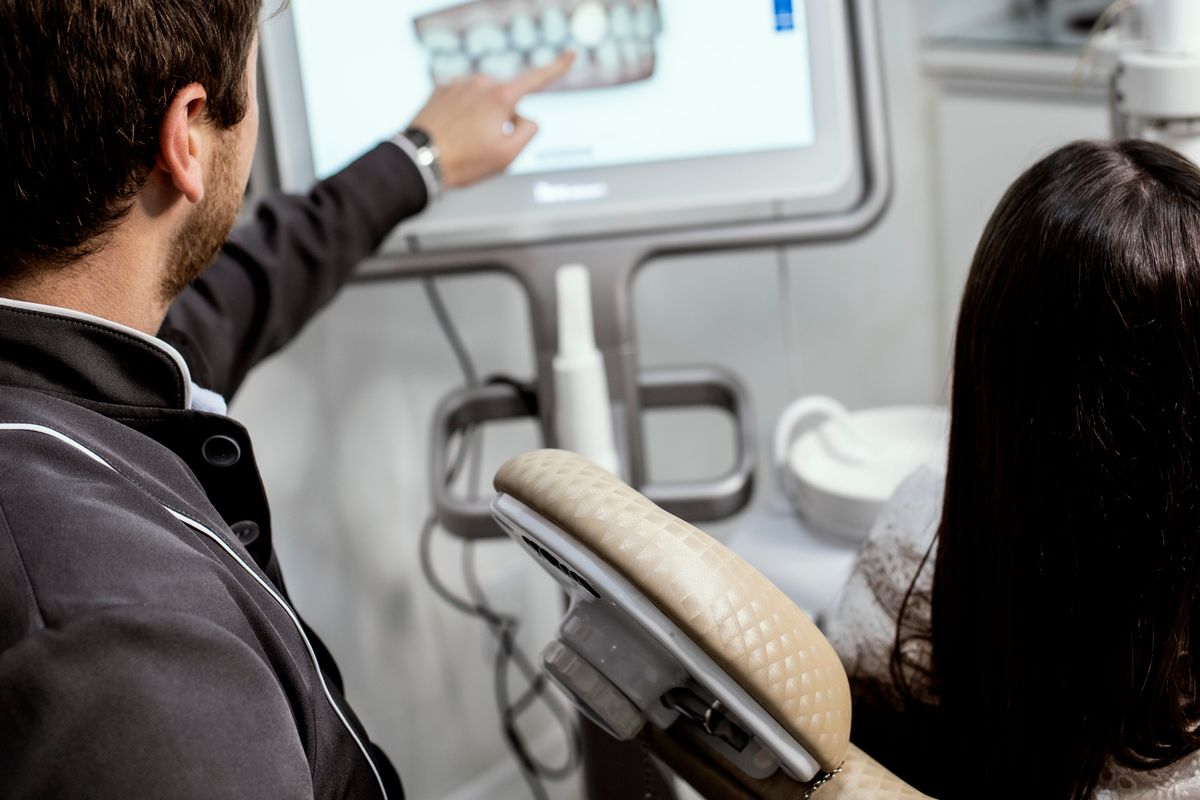 Software de diseño de sonrisa digital analizando la cara y la sonrisa del paciente en la pantalla