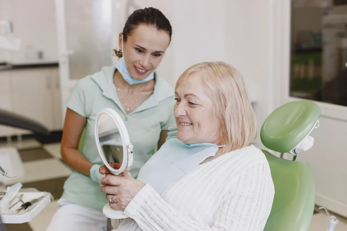 Paciente tranquila y sonriente en el sillón dental tras un curetaje dental con anestesia local